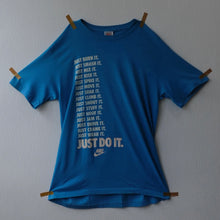 NIKE "JUST BURN IT, JUST SMASH IT, JUST MIX IT, JUST RISK IT, JUST SPIKE IT, JUST MOVE IT, JUST SOAK IT, JUST CLIMB IT, JUST SHOUT IT" T-SHIRT